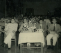 Black-and-white photograph of four officials seated at a table during a formal gathering, with an audience behind them. According to the accompanying caption, the event is an introductory evening for Information Service officials attended by Sri Paku Alam VIII and Information Minister Wiwoho Poerbohadidjojo in Yogyakarta on 6 November 1950.
